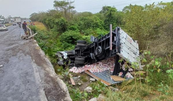 Caminhão carregado de fraldas tomba e cai em ponte na BR-116, em Antônio Cardoso