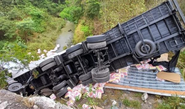 Caminhão carregado de fraldas tomba e cai em ponte na BR-116, em Antônio Cardoso